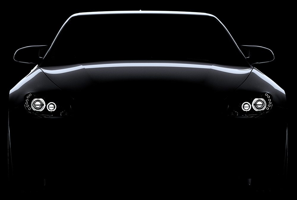 A sleek car silhouette illuminated by subtle light accents in darkness.