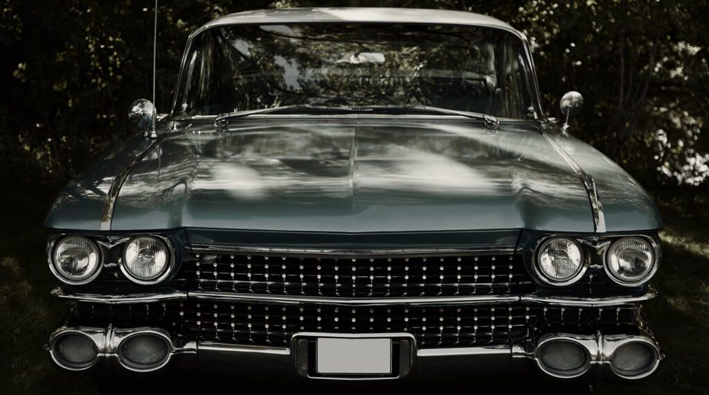 Front view of a vintage car with chrome grille and headlights.