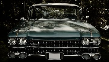 Classic vintage car front with prominent grille and headlights.